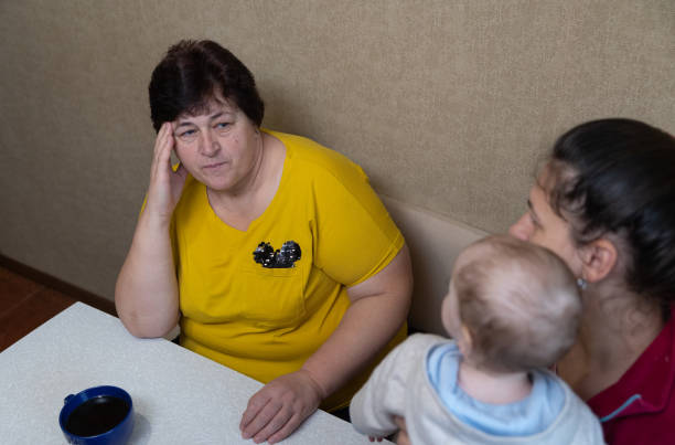 istock The woman experiences a headache while drinking tea with her family. 1451491283