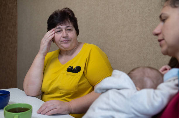 istock The woman experiences a headache while drinking tea with her family. 1451491295