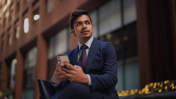 Handsome businessman using smart phone in city