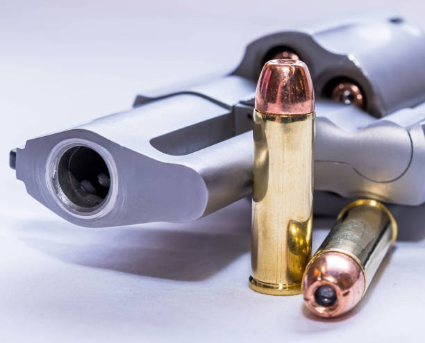 istock Two hollow point bullets next to a 454 casull revolver 1451498595