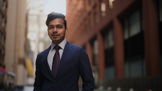 A portrait of a handsome Indian businessman in city.