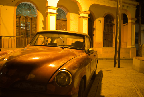 Nightshot of an old car parked in the streets of Santiago de Cuba