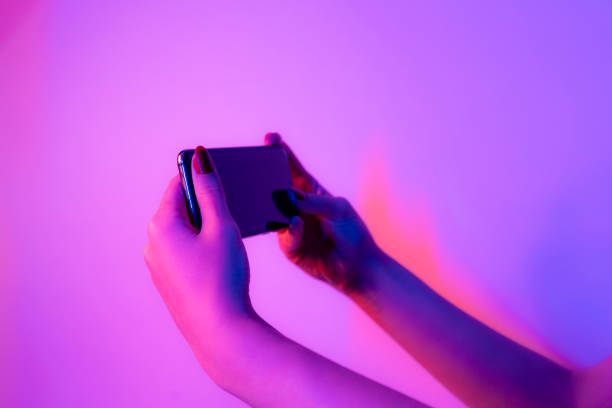 istock smart phone in female hands on a neon background 1451507326