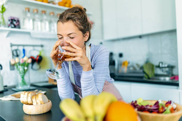 istock Young woman in kitchen drinking wine 1451509086