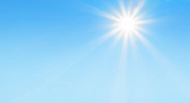 Bright sun with beautiful beams in a blue sky stock photo