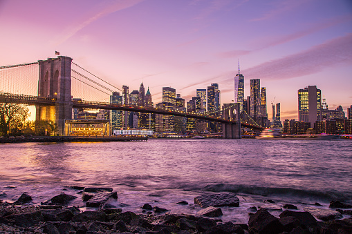New York Lower Manhattan Skyline with the Brooklyn Bridge at dusk.