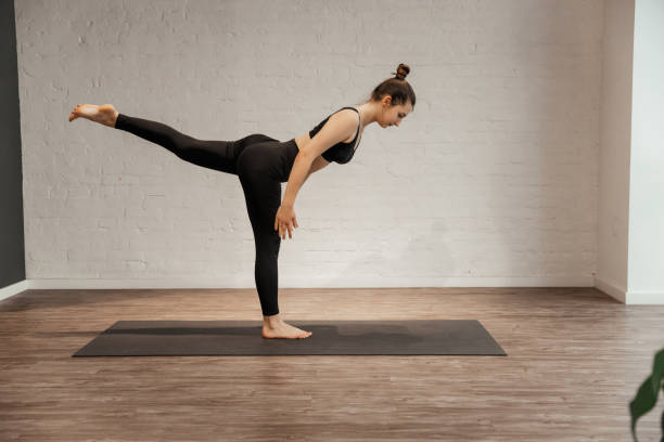 istock Young woman doing sport exercise Warrior Pose. Virabhadasana 1451515377