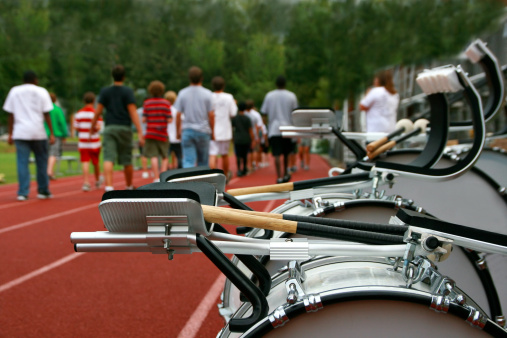 A marching band practices on the high school track before a parade