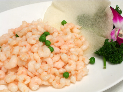 Wok fried shrimps with peas and garnish. A simple looking and popular dish in Chinese cuisine. The shrimps are specially selected for the texture and elegant fragrance, the sauce must not be too thick or watery and must form a coating on the shrimp without them sticking together. Peas are optional depending on the restaurant.