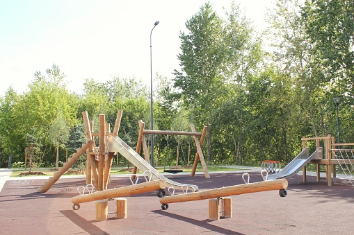 Wooden modern ecological safety children outdoor playground equipment in public park. Nature architecture construction playhouse in city. Children rest and childhood concept. Idea for games on air.