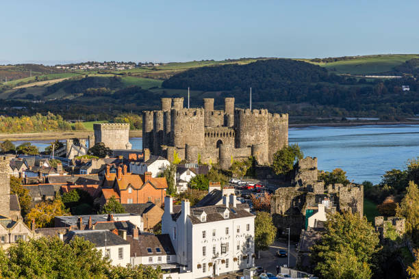 Aerial view of Conwy with Conwy Castle in the background, Wales Conwy previously known in English as Conway, is a walled market town, community and the administrative centre of Conwy County Borough in North Wales. The walled town and castle stand on the west bank of the River Conwy, facing Deganwy on the east bank. The castle was built by Edward I, during his conquest of Wales, between 1283 and 1287. conwy castle stock pictures, royalty-free photos & images