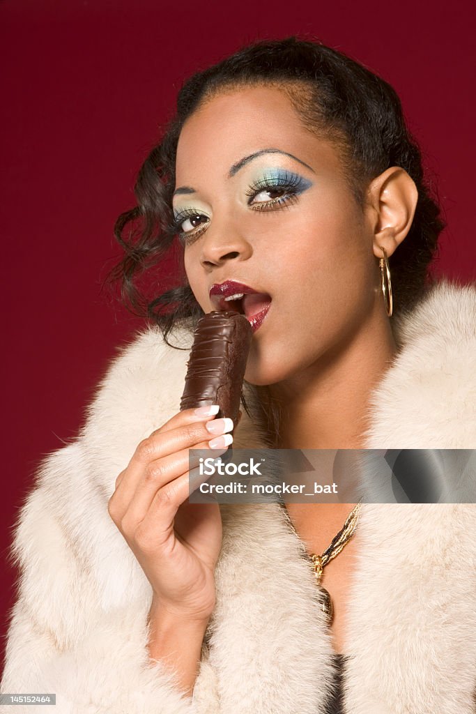 Dziewczyna w Futro jeść czekolady - Zbiór zdjęć royalty-free (Afroamerykanin)