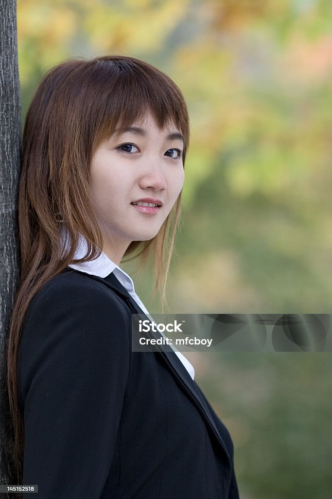 happy girl a commerce student was leaning against a tree. Adult Stock Photo