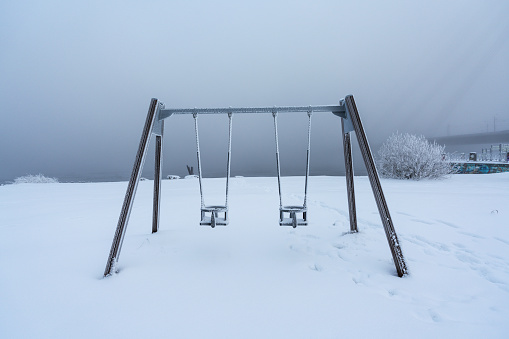 Frosted swing set in the park on the banks of the Daugava river in Riga, Latvia