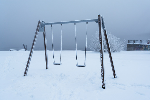 Frosted swing set in the park on the banks of the Daugava river in Riga, Latvia