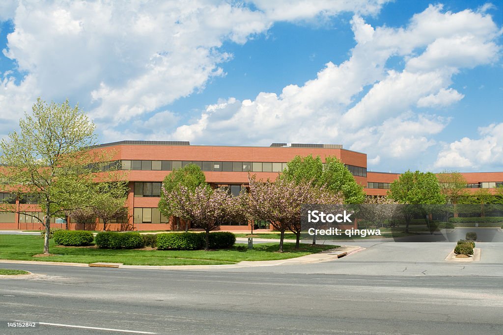 New Brick Office Building, Trees, Suburban Maryland, USA, Blue Sky Sprawling red brick office building in suburban Maryland, United States.  Building is set back from the road, and has low trees in front.   - See lightbox for more Office Park Stock Photo