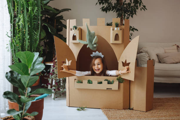 Little girl playing with handmade castle A cute little girl dressed up as a princess while playing at home cardboard house stock pictures, royalty-free photos & images