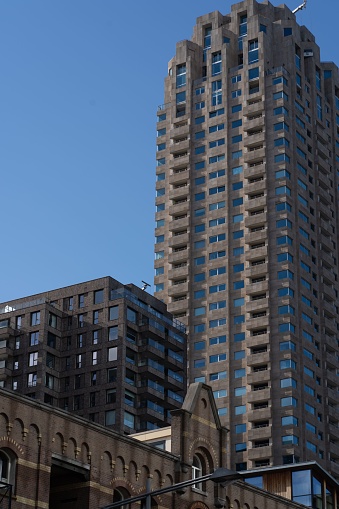 Rotterdam, Netherlands – September 01, 2022: A vertical of a tall rediential buildings in Rotterdam, Netherlands against a blue sky