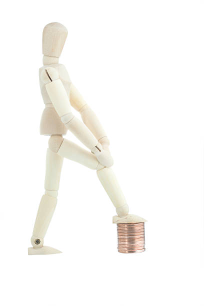 istock Manikin standing on coin pile 145153189