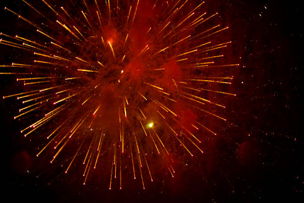 Fireworks in black sky. Explosions of pyrotechnics on holiday. Sparks from fireworks at night. Holiday.