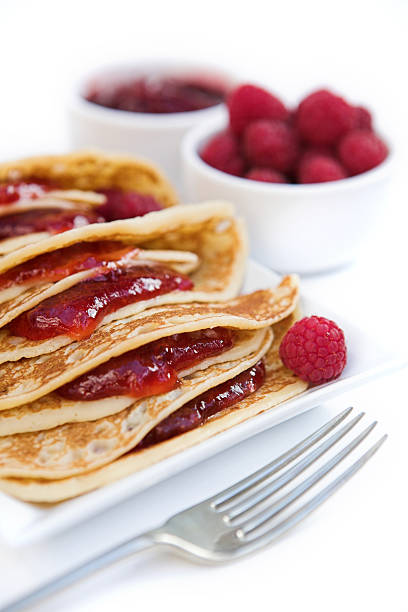 Pancakes with raspberry jam & fresh raspberries stock photo