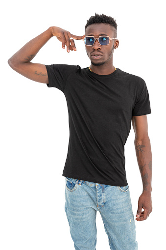 African-American man in black t-shirt wearing sunglasses against white background. Black male model raising his hand and pointing his head with index finger. It represents using your mind by pointing your finger at your brain.