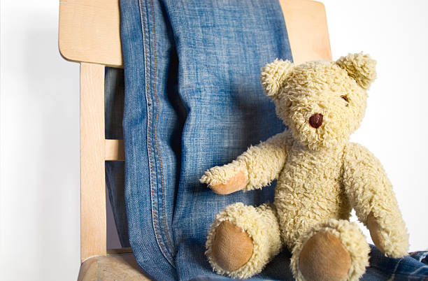 istock teddy bear on chair, jeans fabric, white background 145154535