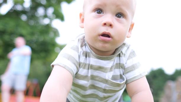 glückliche familie beim picknick. das kleine baby krabbelt auf grünem gras. sommer im park. geschwister kinder spielen im grünen park. familienspaß und freude in playgroung. aktiver sohn kriecht barfuß auf dem feld - furniture barefoot little boys family stock-fotos und bilder