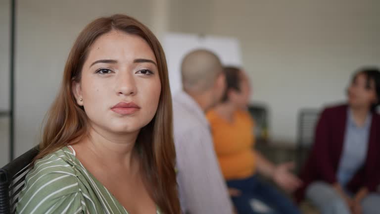 Portrait of young woman during group therapy at mental health center