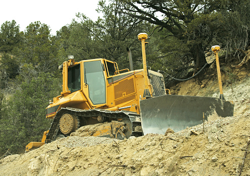 A bulldozer at work with GPS masts on the front blade.