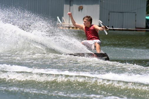 Teenage boy performing a trick on the wakeskate.