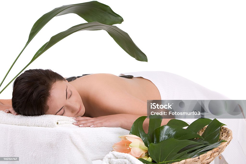 Spa relaxation Beautiful brunette enjoying a hot stone massage in the spa Adult Stock Photo