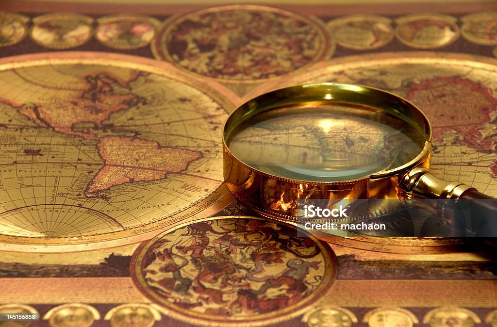 Magnifying glass placed over old map Backgrounds Stock Photo