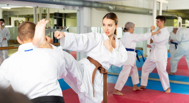 istock Man and woman in kimono sparring together during karate training 1451569423