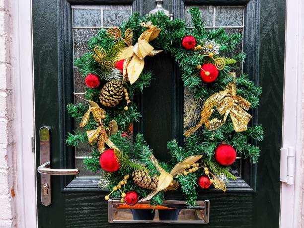 istock Christmas wreath hanging on wooden front door 1451570381