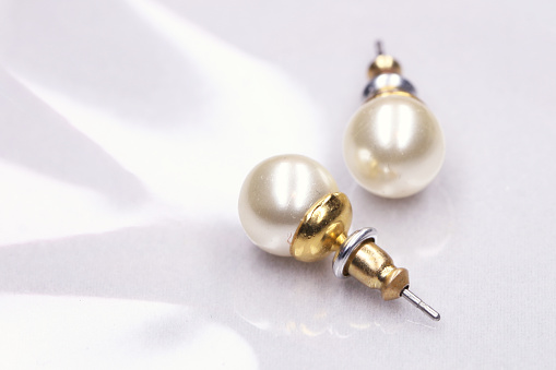 Close-up of two pearl earring on arranged background