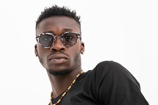 African-American man in black shirt wearing sunglasses against white background.