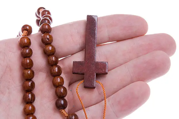 Photo of Hand Holding a Wooden Rosary Cross, Isolated on White Background