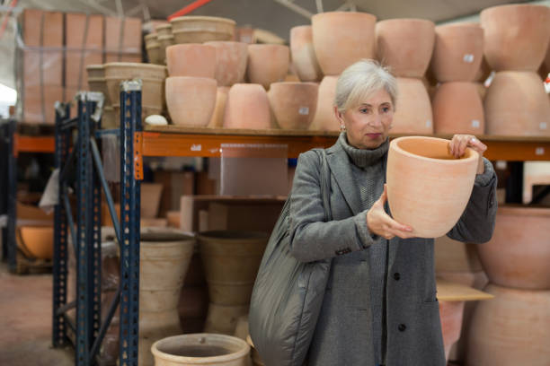 istock Elderly woman looking for flower pots in hypermarket 1451575687