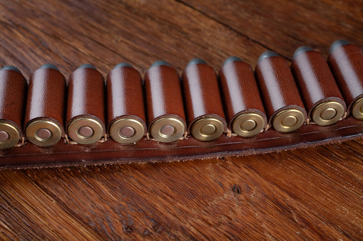 Old west gun belt with ammunition on wooden table