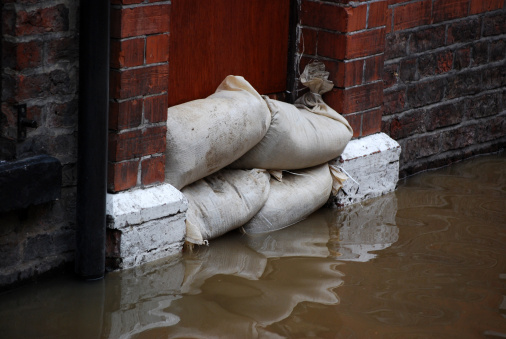 Sandbag barrier in doorway of flooded street in York.