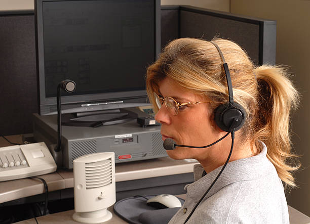 Police dispatcher sitting at a dispatch console A police dispatcher sitting at a dispatch console dispatcher stock pictures, royalty-free photos & images