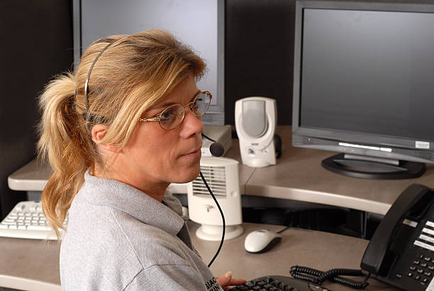 Police dispatcher sitting at dispatch console Police dispatcher sitting at a dispatch console dispatcher stock pictures, royalty-free photos & images