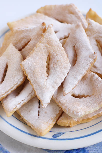 bugnes bugnes (french fritters) on a white and blue plate           beignet stock pictures, royalty-free photos & images