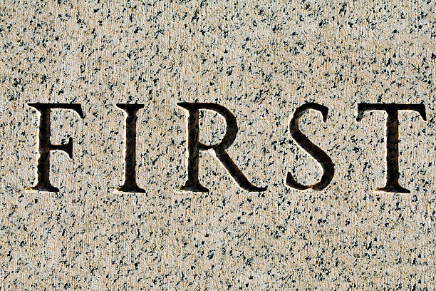Word "First" Carved in Gray Granite