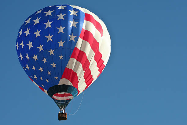 Colorful hot air balloon flying above with blue sky background.