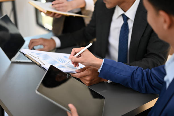 istock A group of professional Asian businesspeople analyzing data on report. cropped image 1451611354