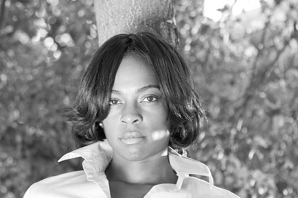 istock Attractive African American Woman Leaning Against Tree, Black and White 145162148