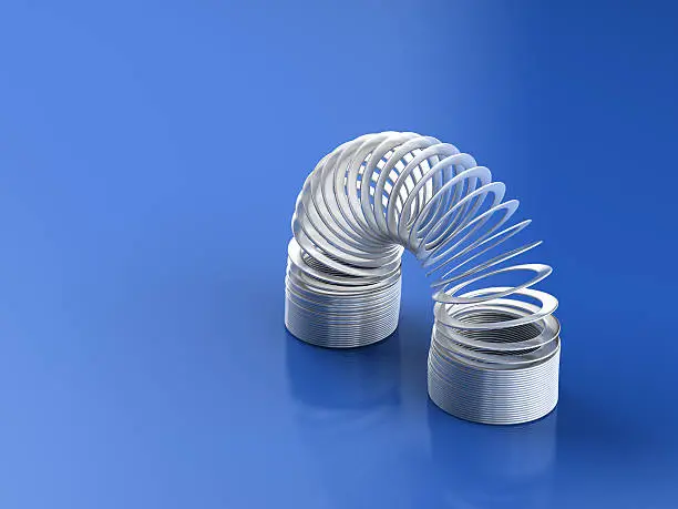 Metal desk toy slinky spring on isolated blur background