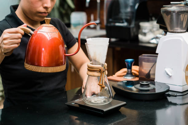 istock Unrecognizable woman pouring water to prepare coffee at work. Copy space. 1451623265